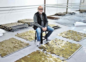 Paulo Pederneiras com parte das placas com tampas de latas de sardinha que formam o cenário de "Piracema" -  (crédito: Gladyston Rodrigues/EM D.A Press)