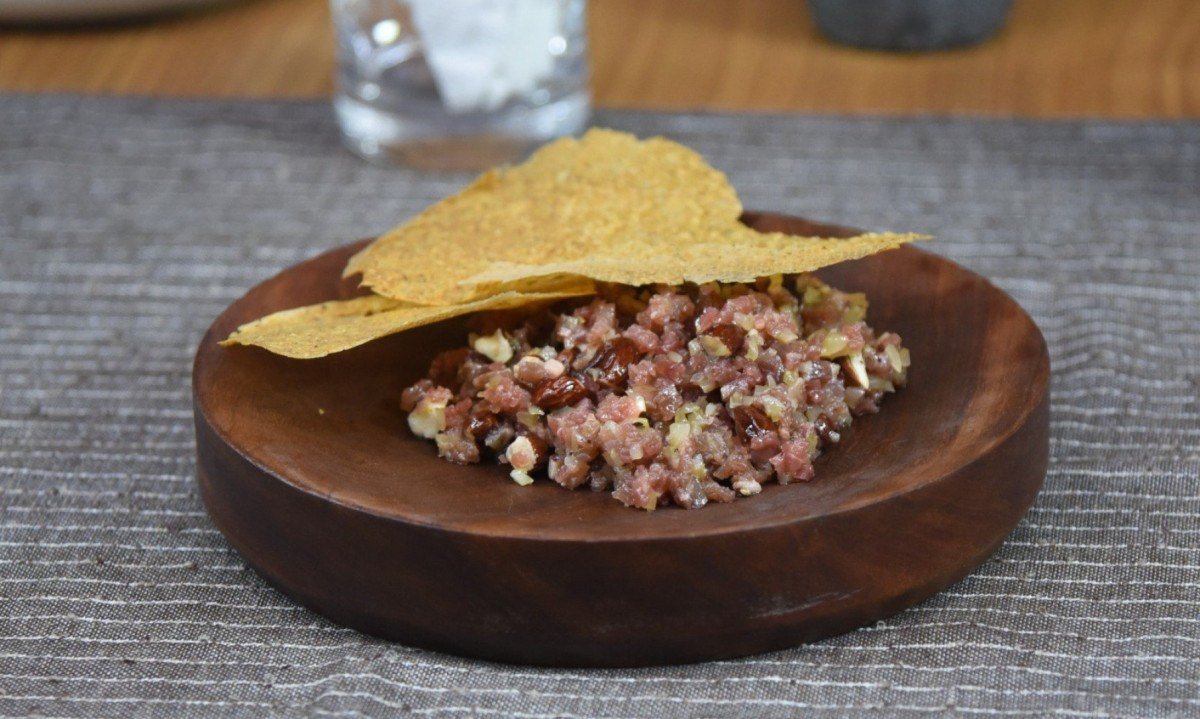 Carne serenada, picles de maxixe, castanha de pequi e telha de angu de milho crioulo: o steak tartar combina sabores regionais