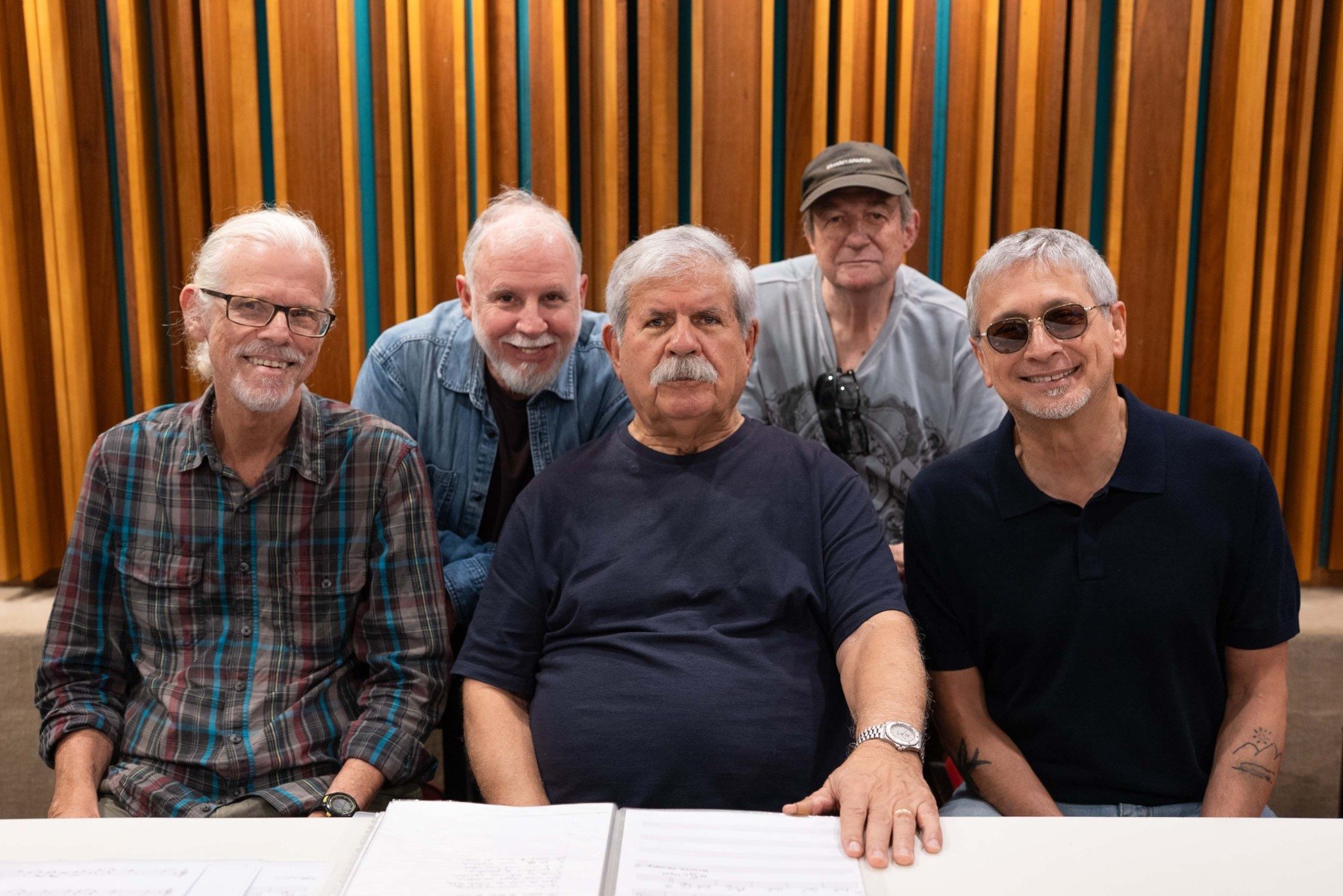 Cantor e compositor Dori Caymmi está cercado pelos quatro músicos do grupo Boca Livre. Os cinco olham para a câmera