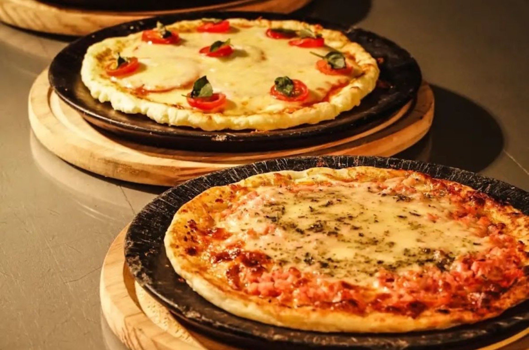 Pizzas com massa de pão de queijo da Boca do Forno (Caprese, com muçarela de búfala, molho de tomate, pesto, tomate e manjericão por R$ 33; de carne seca com catupiri por R$ 29; de frango com catupiri por R$ 26; ou presunto e muçarela por R$ 23)-Danielle Zabeu/Divulgação