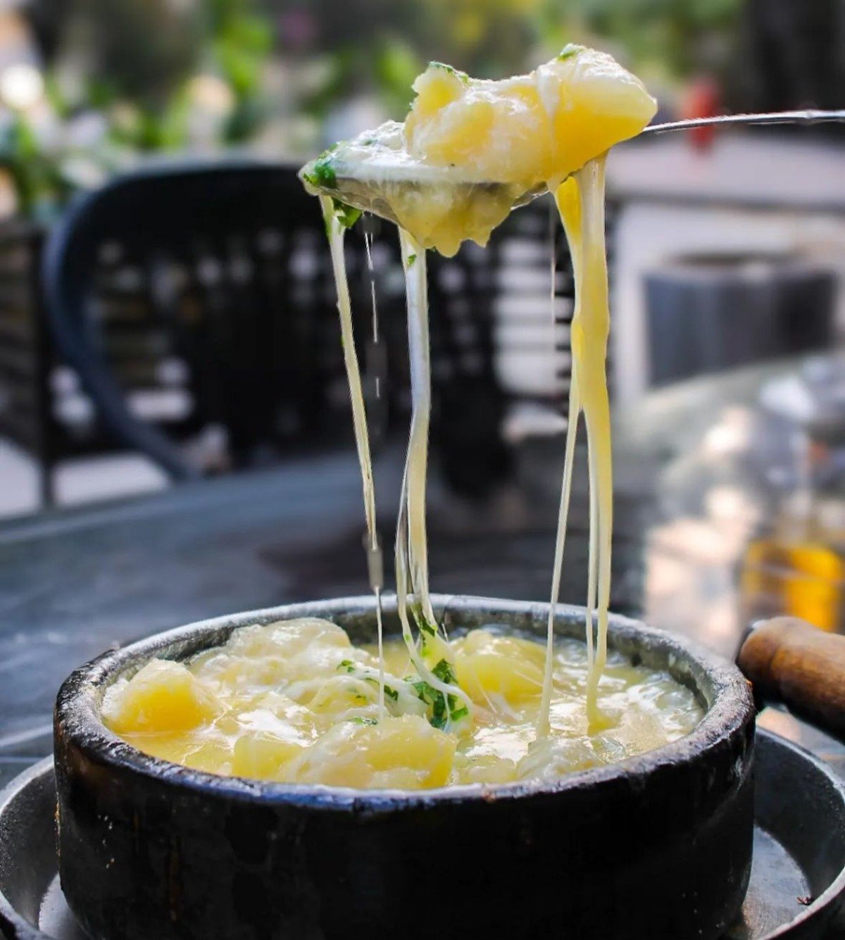 Mandioca cozida na manteiga de garrafa servida borbulhando na panela de pedra com queijo do Loop Gastrobar (R$ 36)-Carolina Cauper/Divulgação