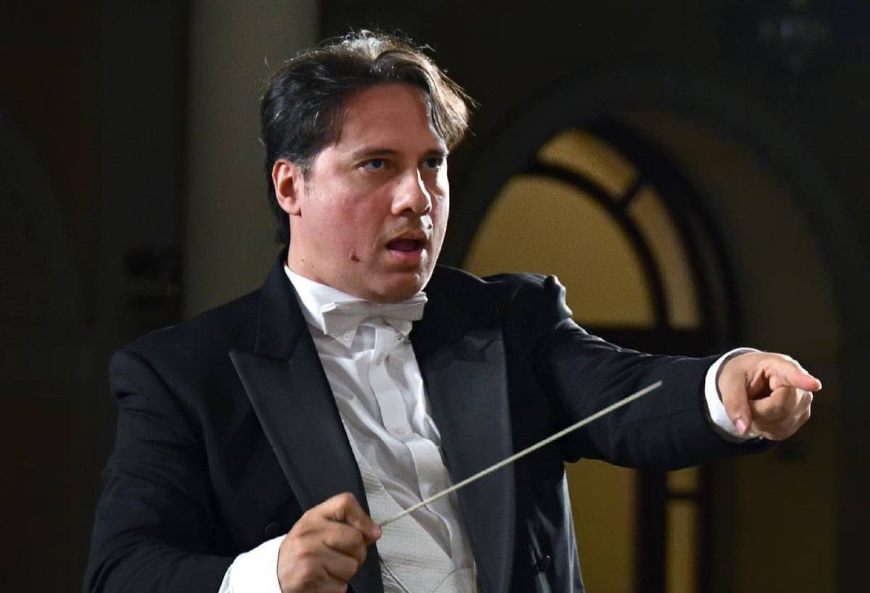 Maestro Miguel Campos Neto segura a batuta durante concerto