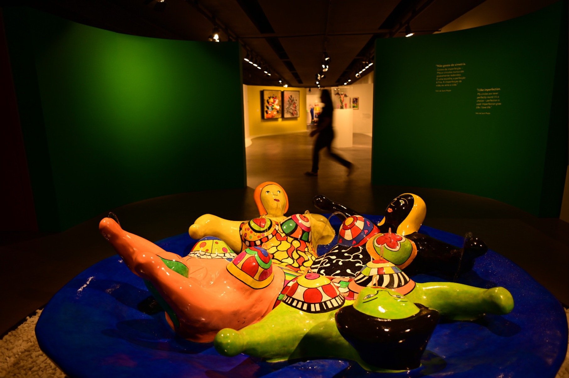 Figuras femininas coloridas estão deitadas em círculo, sob base azul-marinho, é uma das esculturas de Niki de Saint Phalle expostas na Casa Fiat, em Belo Horizonte