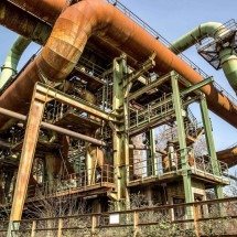 Indústria tem crescimento em 2025 pelo setor extrativo -  Low angle shot of metal pipes and structures with a clear blue sky
