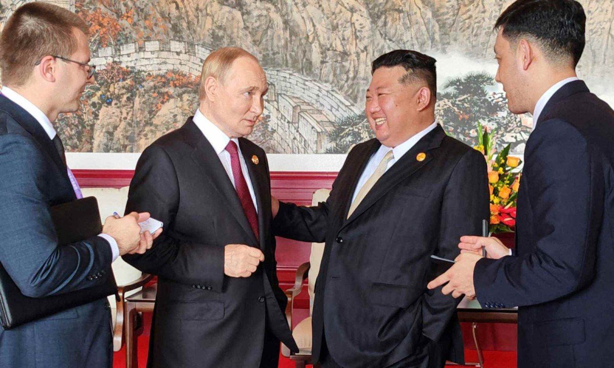 Vladimir Putin e Xi-Jinping em momento descontraído durante encontro em Beijing -  (crédito: AFP PHOTO/KCNA VIA KNS)