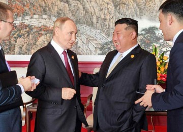 Vladimir Putin e Xi-Jinping em momento descontraído durante encontro em Beijing -  (crédito: AFP PHOTO/KCNA VIA KNS)