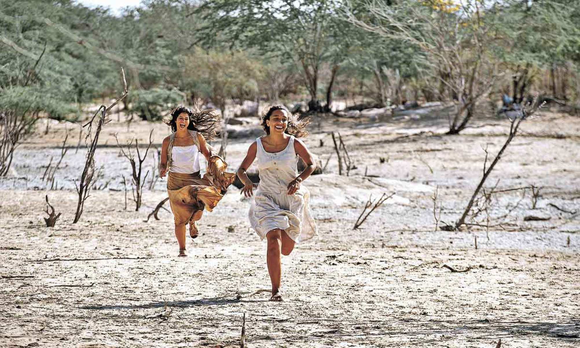 Duas mulheres correm no sertão nordestino em cena da novela Guerreiros do sol