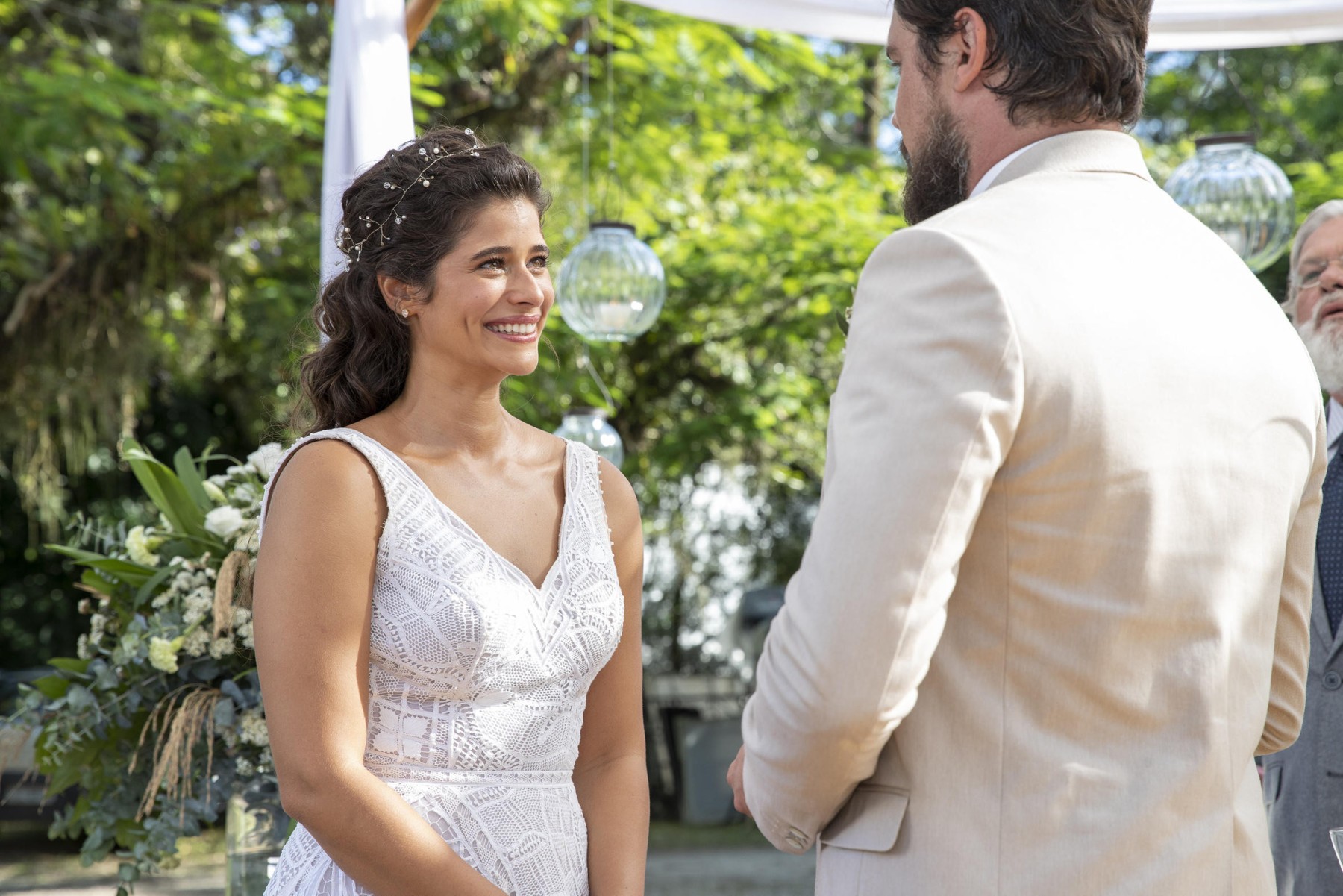 Atriz Isadora Cruz sorri, vestida de noiva, em cena da novela Mar do sertão