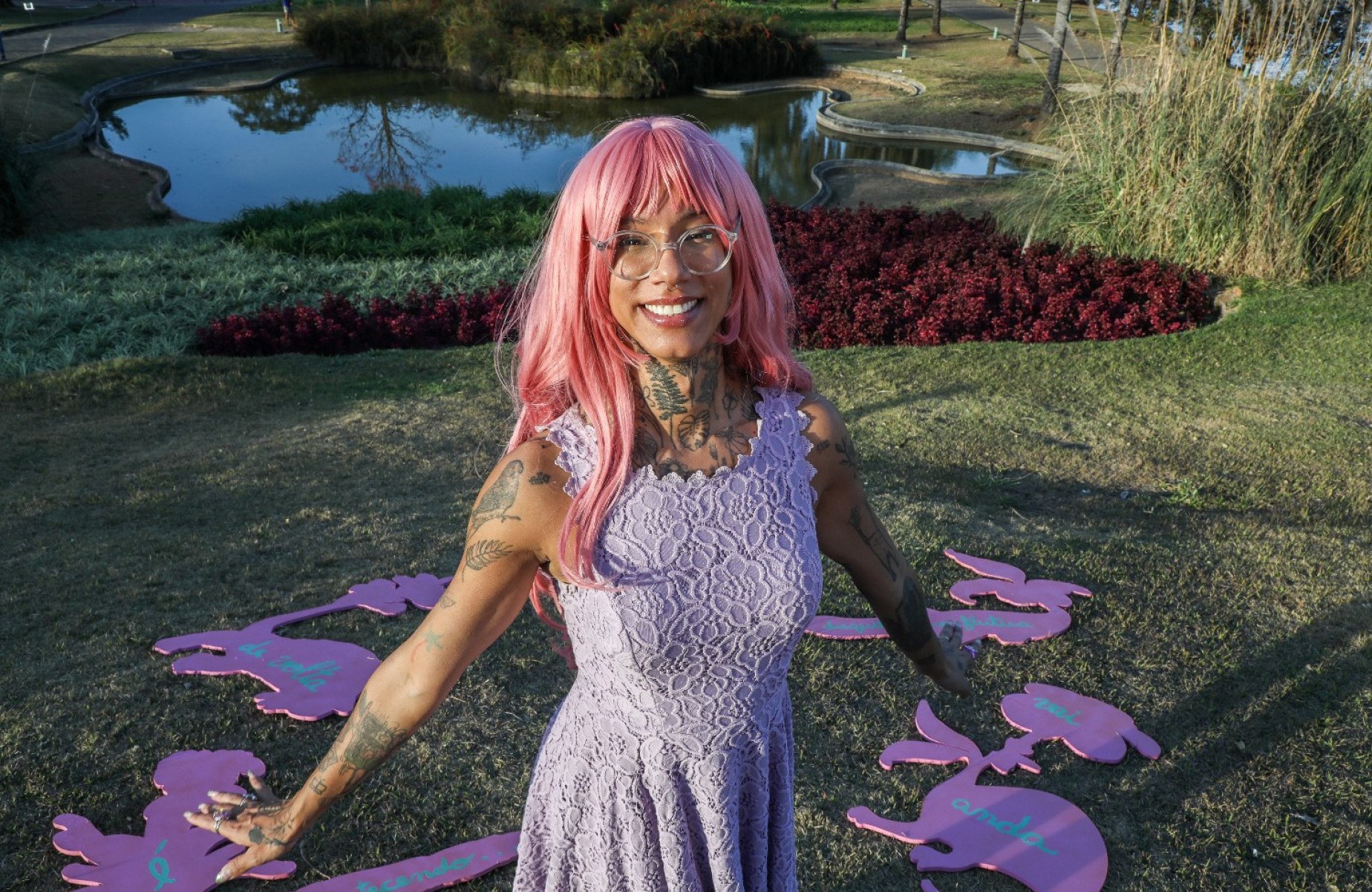 Artista Efe Godoy sorri, diante dos jardins de Burle Marx no Museu de Arte da Pampulha, em Belo Horizonte