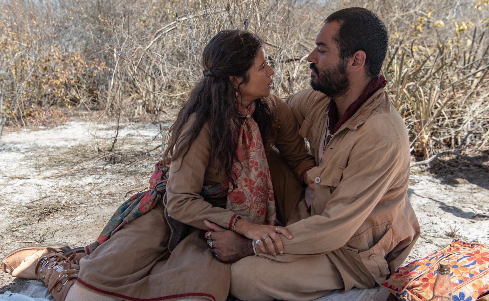 Atores Isadora Cruz e Thomás Aquino, vestidos como cangaceiros, estão abraçados na novela Guerreiros do sol