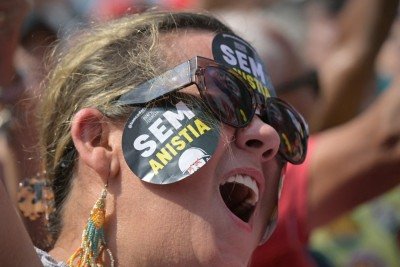 A woman bearing stickers on her face reading 'No amnesty' shouts slogans during a protest against a constitutional amendment known as the Shielding Project, which requires Congress to authorize any criminal charges against deputies and senators through a secret vote, in Sao Paulo, Brazil, on September 21, 2025. Earlier this week, Brazil's Chamber of Deputies, with a conservative majority, approved a parliamentary initiative that extends immunity for legislators and an amnesty project that could benefit far-right former president Jair Bolsonaro, sentenced to 27 years in prison for coup-plotting. (Photo by NELSON ALMEIDA / AFP)
      Caption  -  (crédito: NELSON ALMEIDA/AFP)