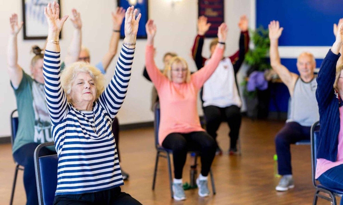 Idosos sentados fazem ginástica, levantando os braços; imagem meramente ilustrativa -  (crédito: Centre for Ageing Better/Pexels)