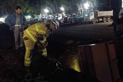 Bombeiros usaram um trator para manter a carreta estável durante o resgate ao motorista que estava retido sob o veículo que poderia tombar -  (crédito: CBMMG/Divulgação)