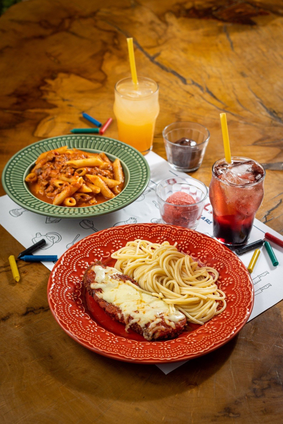Enquanto comem parmegiana de frango com espaguete na manteiga ou penne à bolonhesa, os pequenos se divertem colorindo o jogo americano d'O Italiano