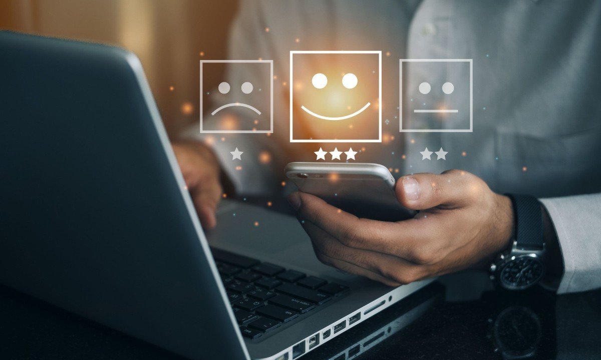  Business man holding phone wiht virtual screen on the happy Smiley face icon to give satisfaction in service. rating very impressed. Customer service and Satisfaction concept
     -  (crédito: DINO)