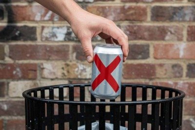Pessoa descarta latinha de bebida alcoólica em cesto de lixo; imagem meramente ilustrativa -  (crédito: imagem gerada por inteligência artificial/acervo Estado de Minas)