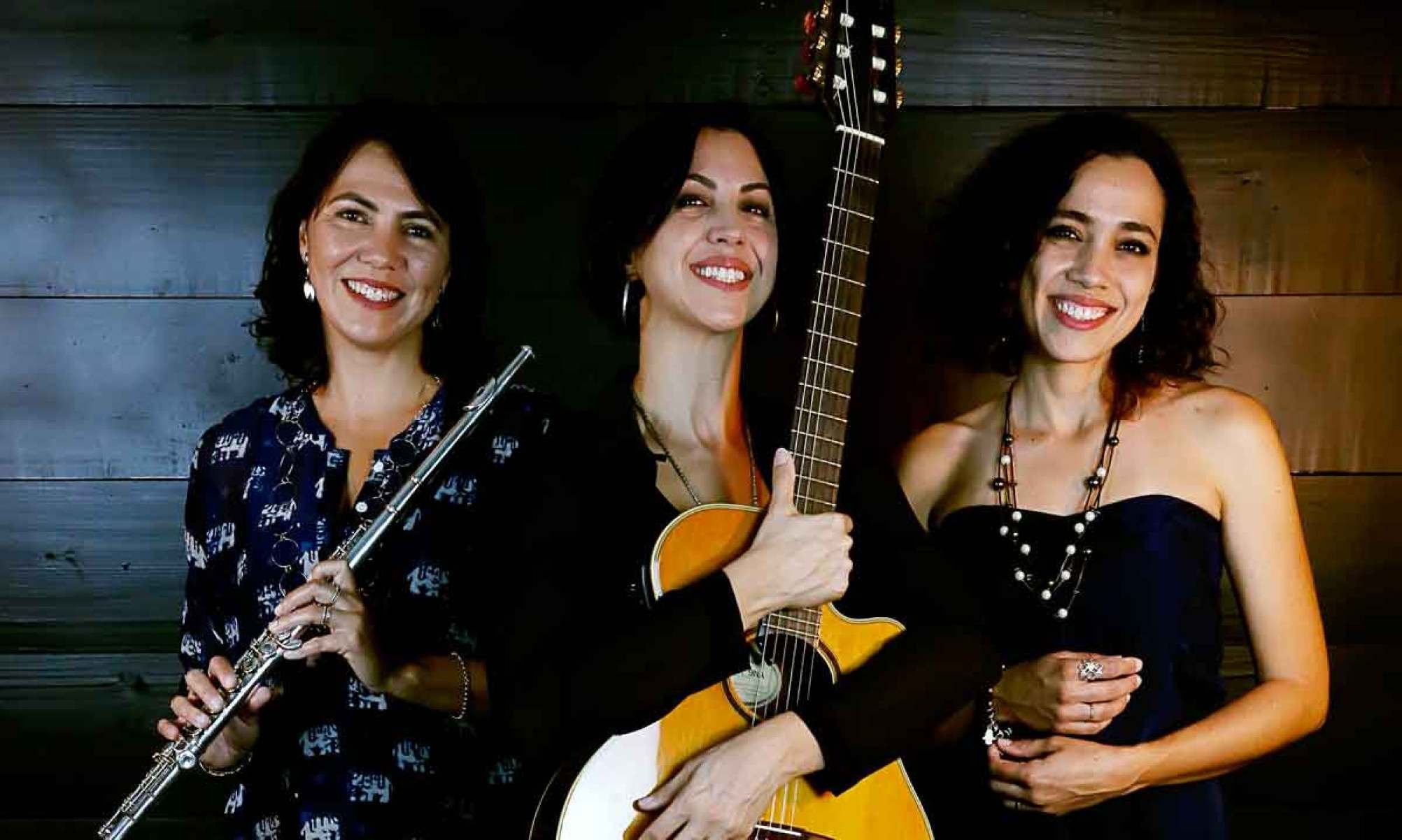Segurando seus instrumentos musicais, as irmãs Flávia, Lúcia e Marina Ferraz, do Trio Amaranto, encaram a câmera 