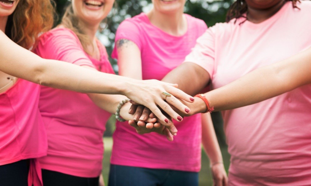 Mulheres de camiseta rosa se dão as mãos; campanha de combate ao câncer de mama deve ser permanente -  (crédito: Freepik)