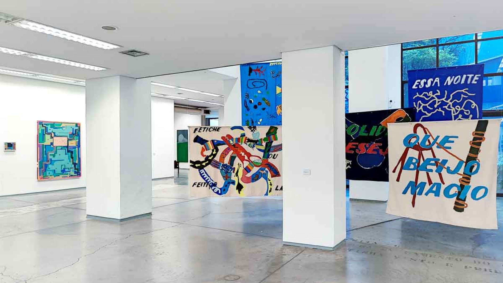 Foto mostra pinturas com palavras coloridas, onde se l&ecirc; fetiche e a frase Que beijo macio, que est&atilde;o expostas na Albuquerque Contempor&acirc;nea Galeria de Arte, em Belo Horizonte