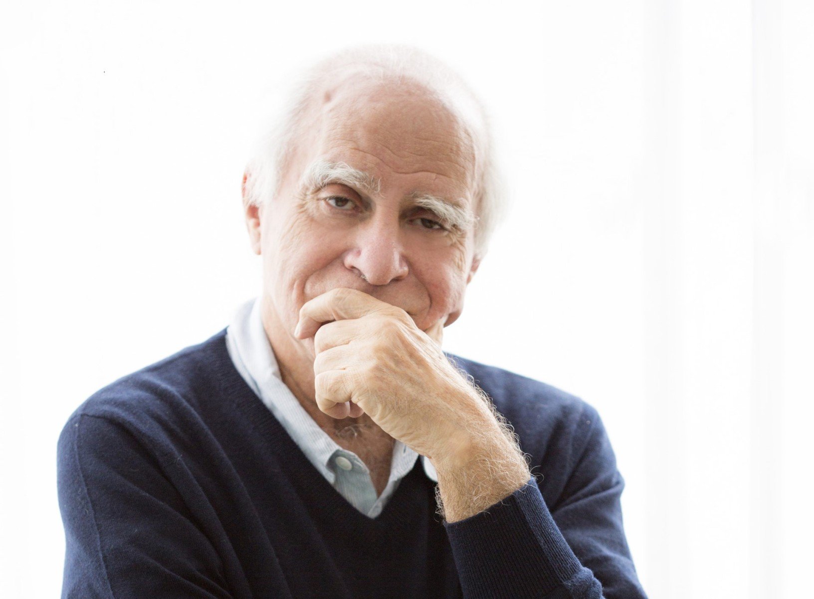 Escritor Ign&aacute;cio de Loyola Brand&atilde;o tem a m&atilde;o no queixo, usa blusa escura e olha para a c&acirc;mera