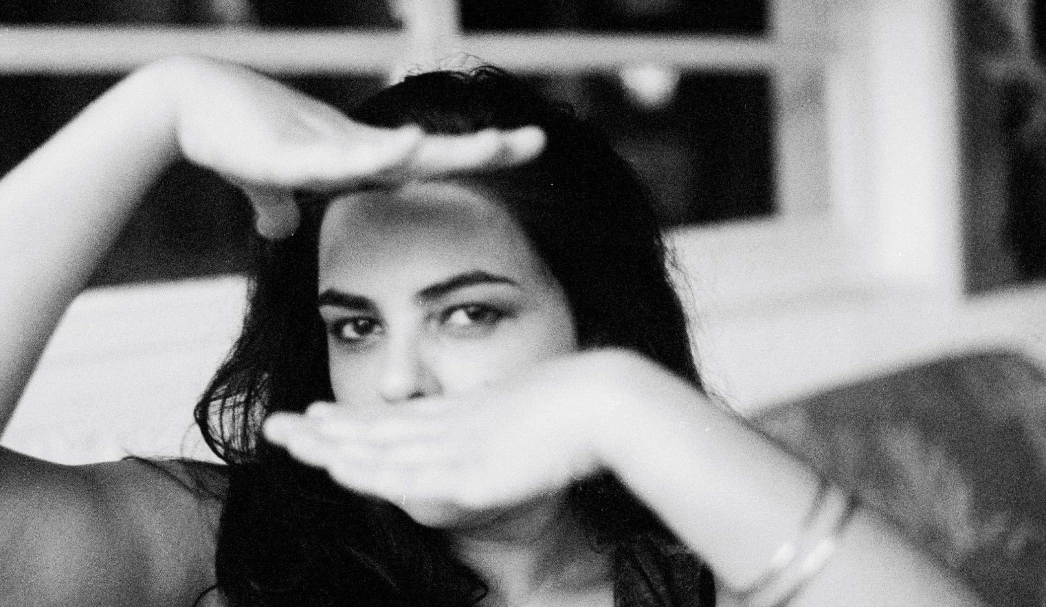 Cantora Ava Rocha mostra parte do rosto, emoldurado pelas duas m&atilde;os