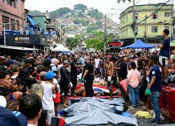 Moradores observam corpos enfileirados na Praça São Lucas, na favela Vila Cruzeiro, no complexo da Penha, Rio de Janeiro, Brasil, em 29 de outubro de 2025, após a Operação Contenção -  (crédito: PABLO PORCIUNCULA / AFP)