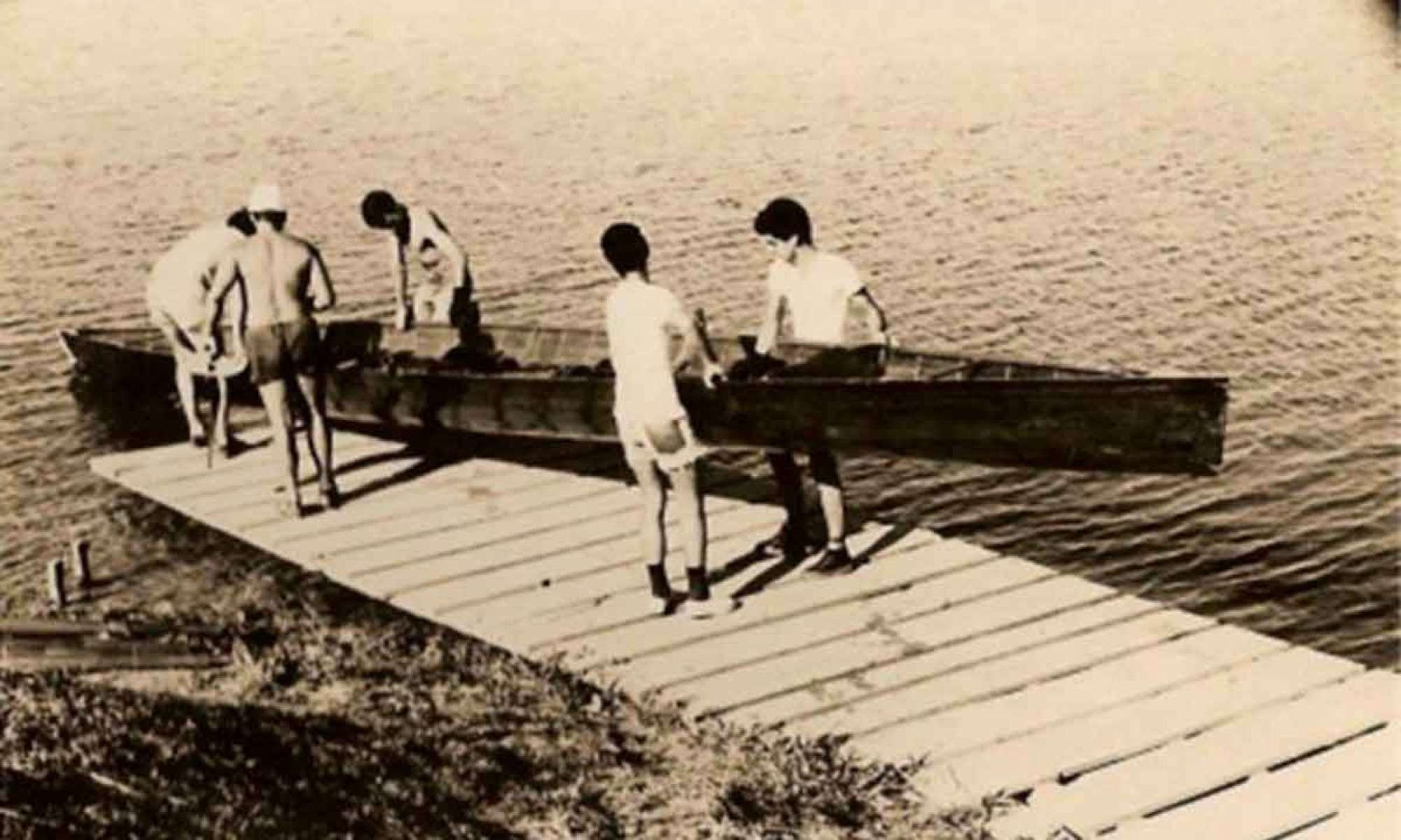 Na foto histórica do mesmo local, jovens da Escola de Remo da Pampulha levam embarcação para o lago