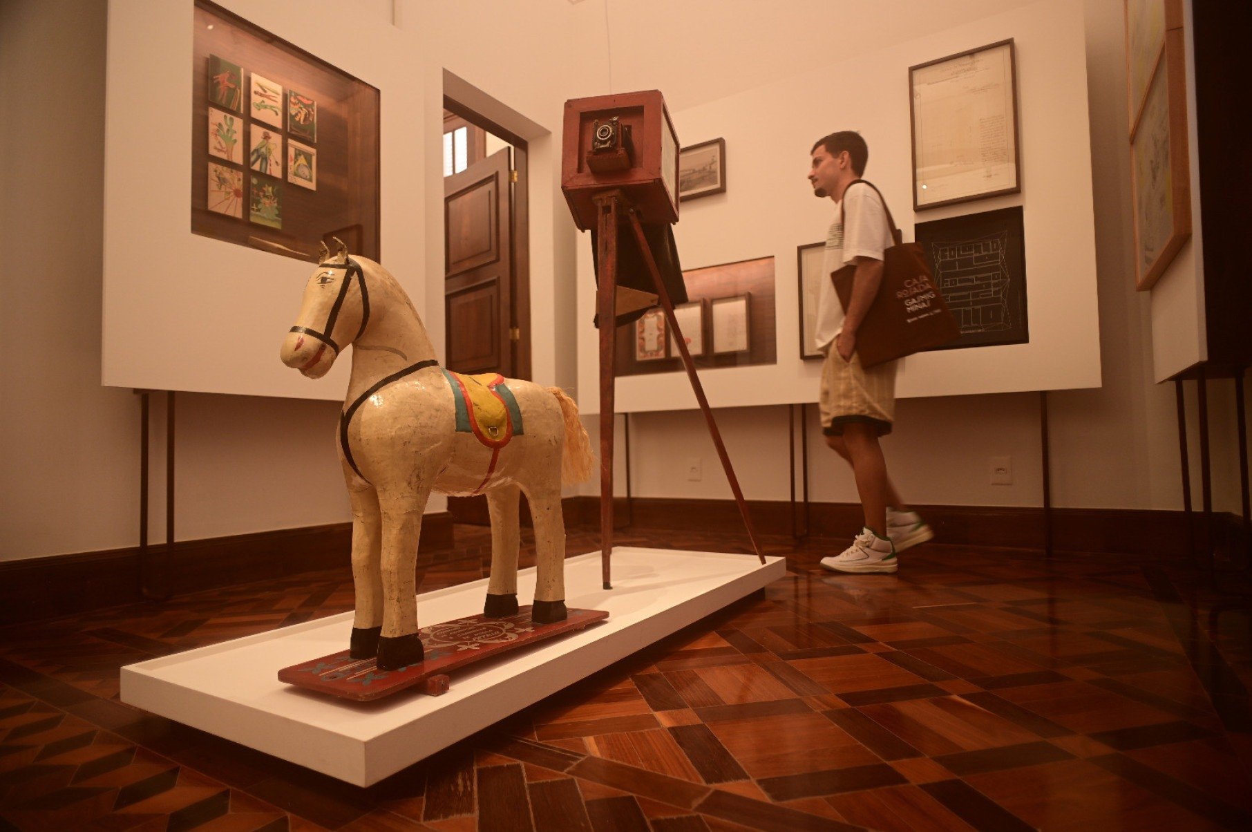 Escultura antiga de um cavalo de brinquedo está no centro de sala da Casa Rosada, em BH, e faz parte da exposição Habitar o/in/visível 
