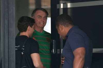Ex-presidente Jair Bolsonaro, com sorriso no rosto, recebe na porta de casa, onde cumpre prisão domiciliar, o deputado federal Nikolas Ferreira -  (crédito: Reuters/Folhapress)