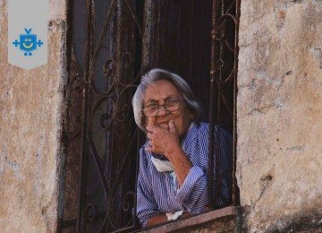 Idosa observa a rua pela janela, simbolizando reflexão sobre futuro e planejamento financeiro para os próximos 10 anos, tema central da pílula de +10 anos. -  (crédito: Reprodução Educando seu Bolso)