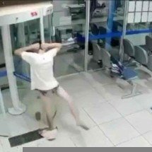 Rapaz fica só de cueca após ficar preso em porta giratória de banco - Reprodução
