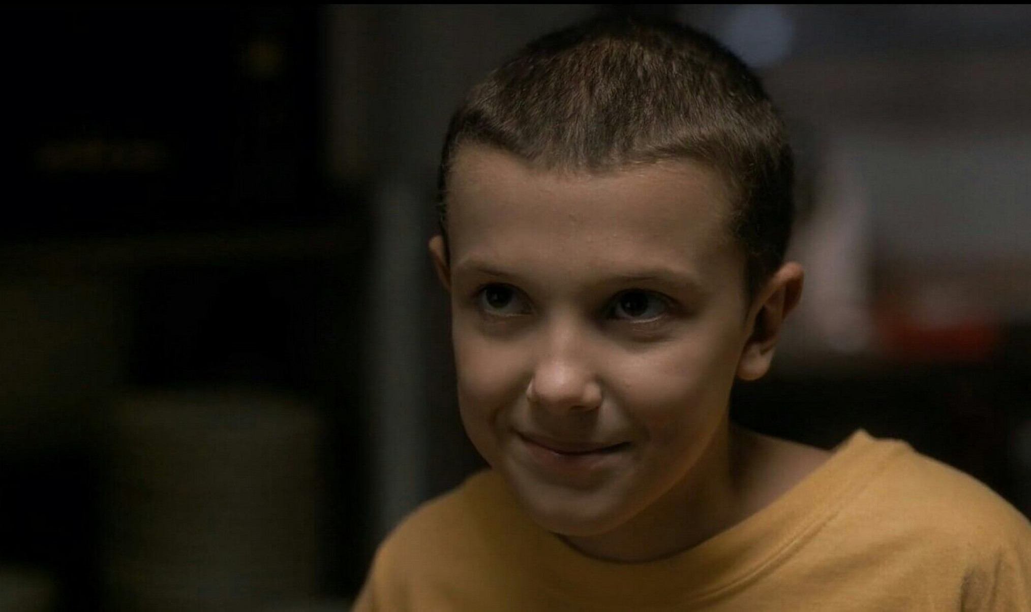   Atriz Millie Bobby Brown, de cabelo bem curto, na serie Stranger things 