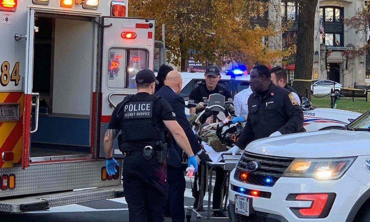 Homem n&atilde;o identifcado, vestindo farda militar, &eacute; levado em maca para uma ambul&acirc;ncia, no local do atentado que feriu dois soldados da Guarda Nacional dos EUA, em  Washington, na tarde de quarta-feira (26/11)
