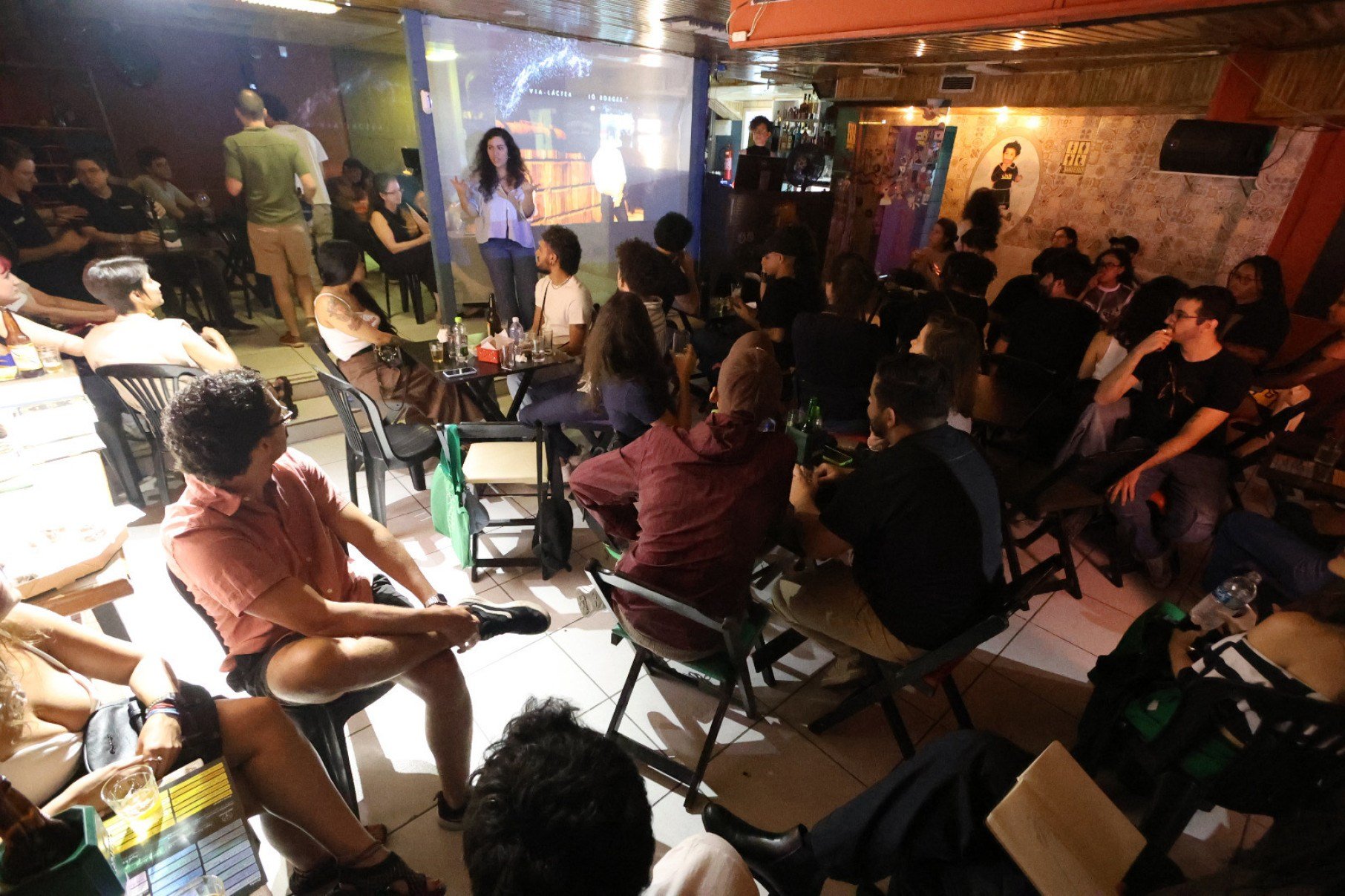 Foto mostra interior de bar em BH cheio de gente