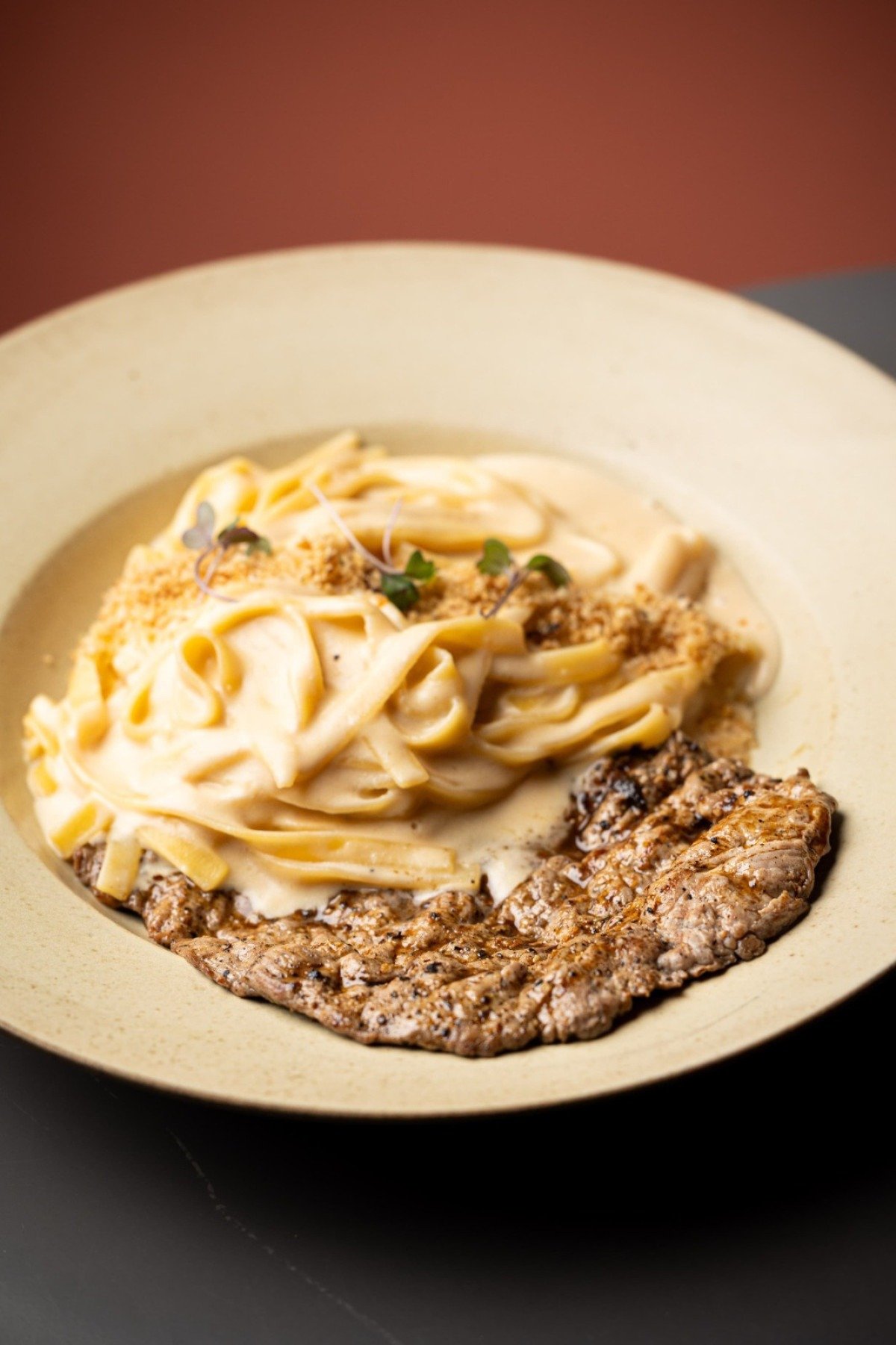 Antigo no cardápio, o fettuccine com molho branco e paillard de filé-mignon simboliza 38 anos de história