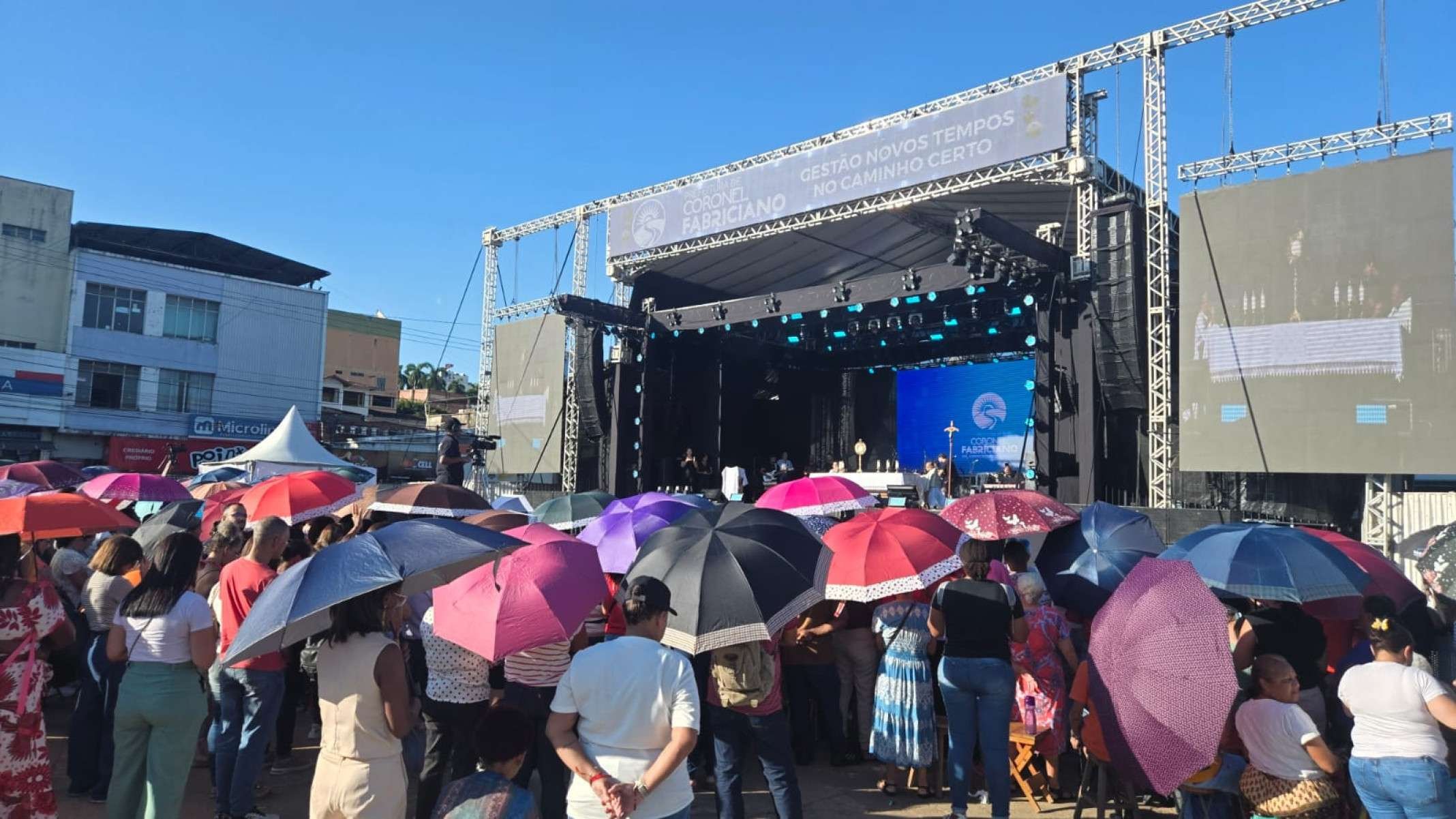 Fiéis usaramn sobrinhas e guarda-chuvas como abrigo do Sol de 30ºC em Coronel Fabriciano