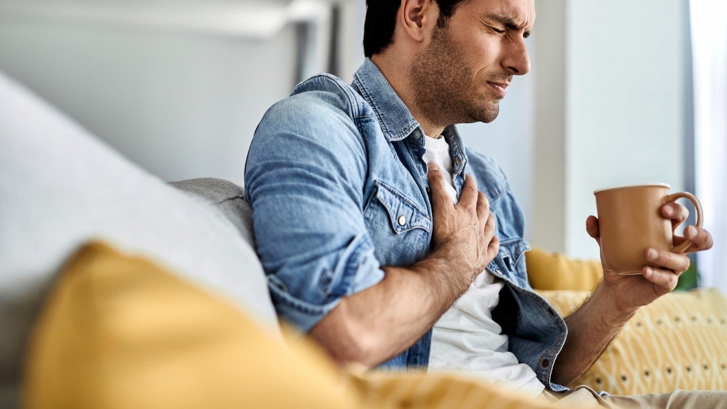 Infarto em jovens: 7 sinais de alerta que não podem ser ignorados - &amp;lt;a href=&amp;quot;https://br.freepik.com/fotos-gratis/jovem-sentindo-se-doente-e-segurando-o-peito-de-dor-enquanto-bebia-cha-na-sala-de-estar_26343755.htm#fromView=search&amp;amp;page=1&amp;amp;position=0&amp;amp;uuid=d85ab5d0-156a-4e54-b51a-3249b9fecd13&amp;amp;query=infarto&amp;quot;&amp;gt;Imagem de Drazen Zigic no Freepik&amp;lt;/a&amp;gt;