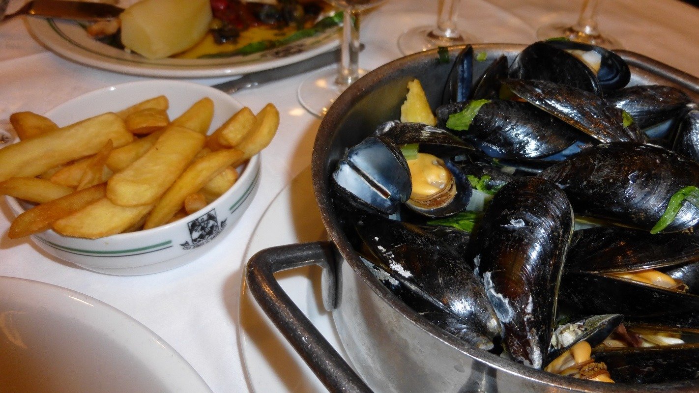 O tradicional Moules-frites, prato nacional da Bélgica, combina mexilhões frescos cozidos com um acompanhamento de batatas fritas crocantes. - (crédito: By Bloguer - Own work, CC BY-SA 4.0, https://commons.wikimedia.org/w/index.php?curid=34994827)