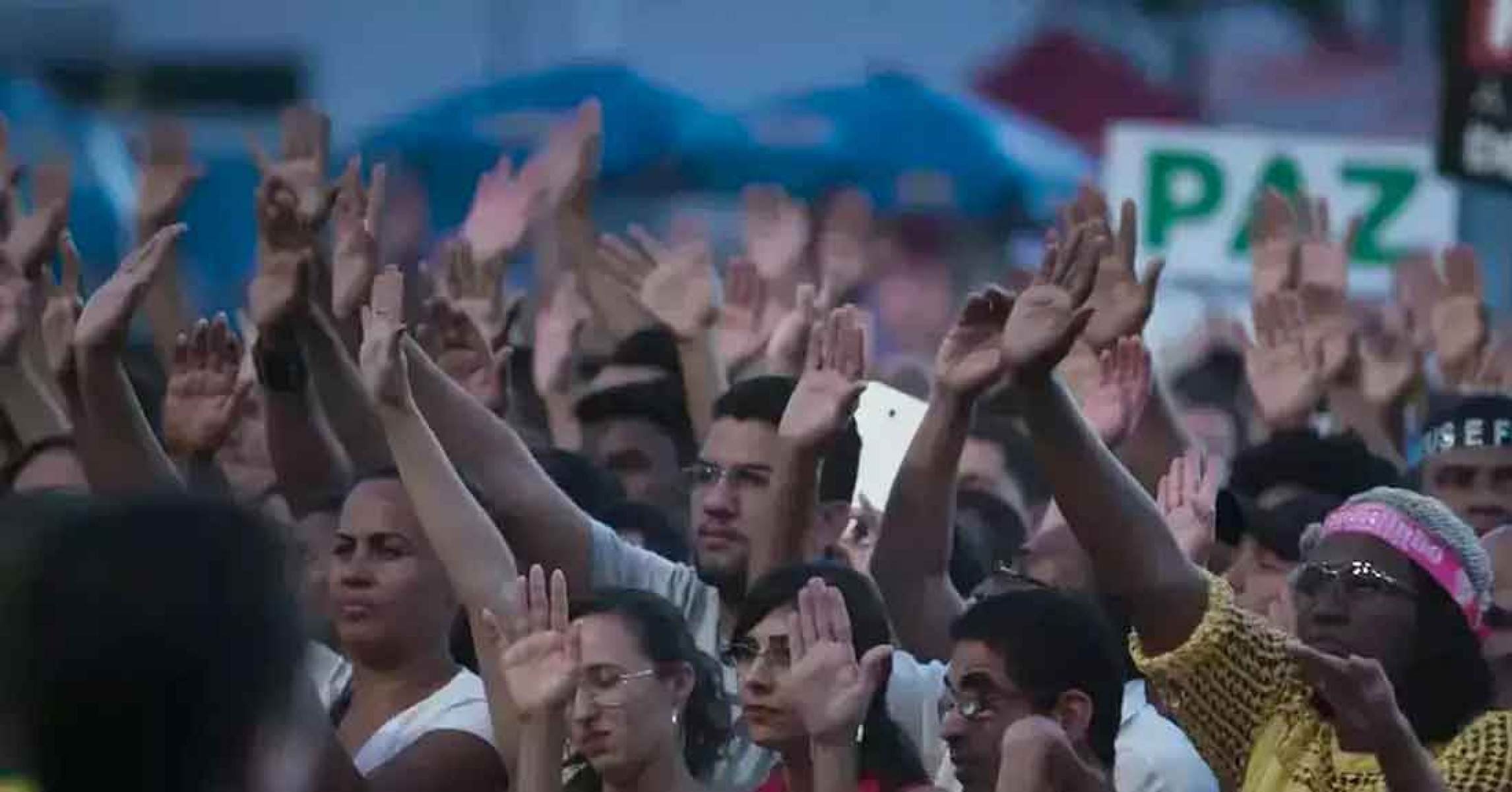 Multidão ergue as mãos em culto evangélico no filme Apocalipse nos trópicos