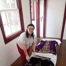 A museóloga da arquidiocese, Fabiana Martins, mostra a túnica e a capa que apresentam o desgaste provocado pelo tempo -  (crédito: Leandro Couri/EM/D.A PRESS)