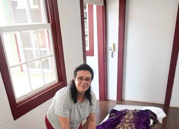 A museóloga da arquidiocese, Fabiana Martins, mostra a túnica e a capa que apresentam o desgaste provocado pelo tempo -  (crédito: Leandro Couri/EM/D.A PRESS)