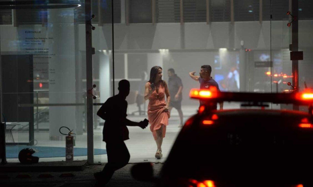 Uma concessionária localizada à direita do prédio em chamas retirou os veículos estacionados no local devido aos riscos potenciais do incêndio-Túlio Santos/EM/D.A Press