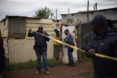  Agentes do Serviço de Polícia da África do Sul isolaram a área do crime em um bar em Bekkersdal -  (crédito: Foto por EMMANUEL CROSET / AFP)