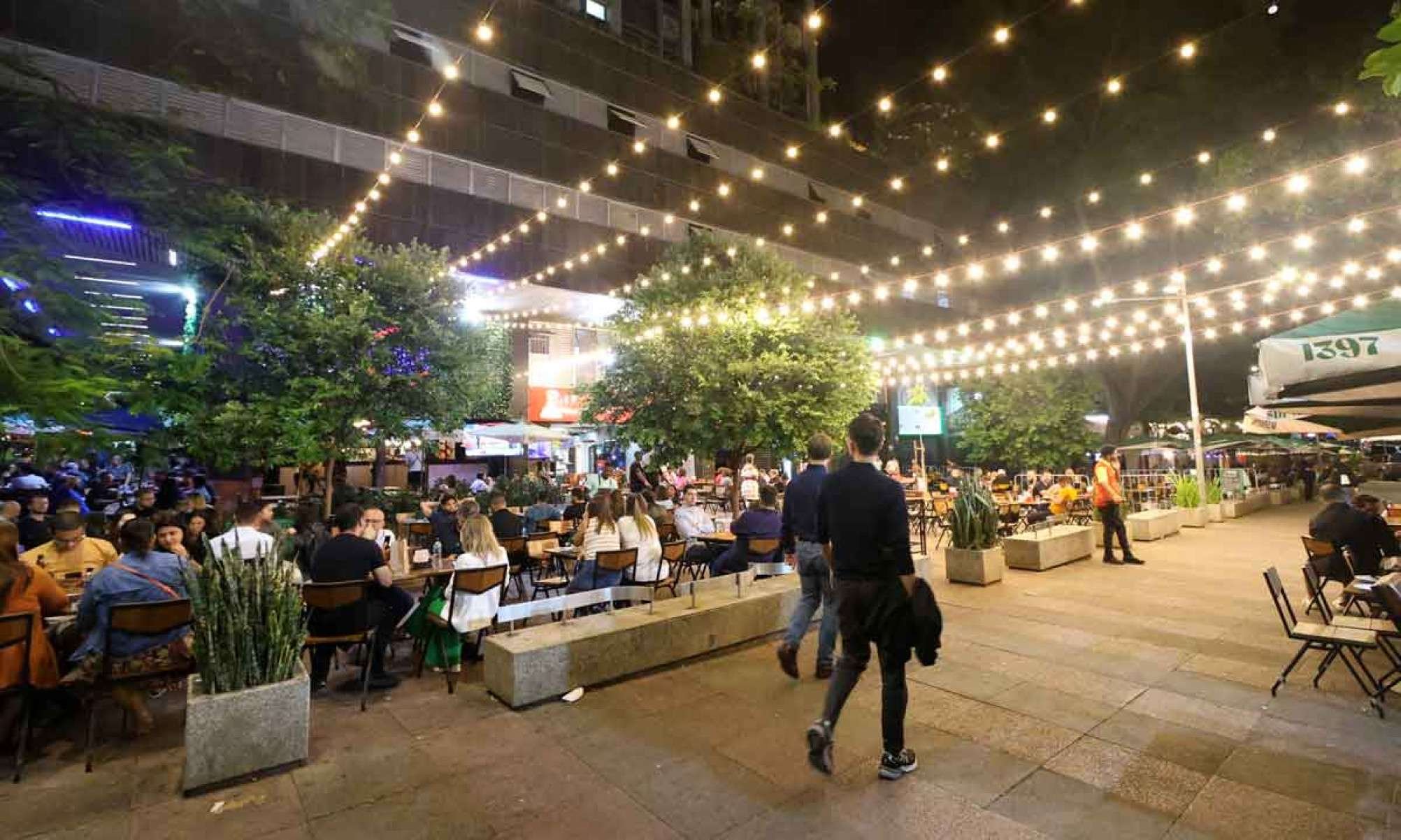 Movimento noturno nos bares, com mesas na cal&ccedil;ada