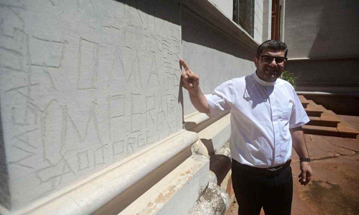 Padre George Raleb Massis mostra o resultado da a&ccedil;&atilde;o de v&acirc;ndalos na fachada da Igreja, um dos muitos problemas do local