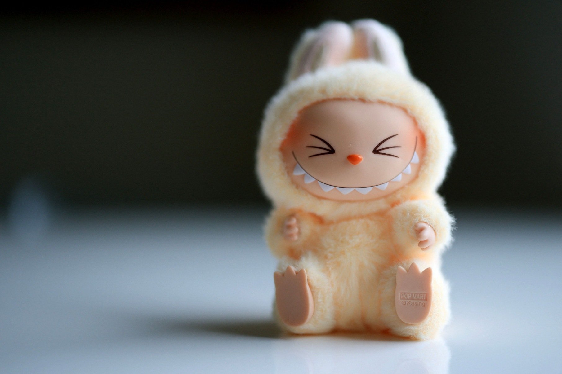 Boneco Labubu vestido de amarelo est&aacute; sorrindo