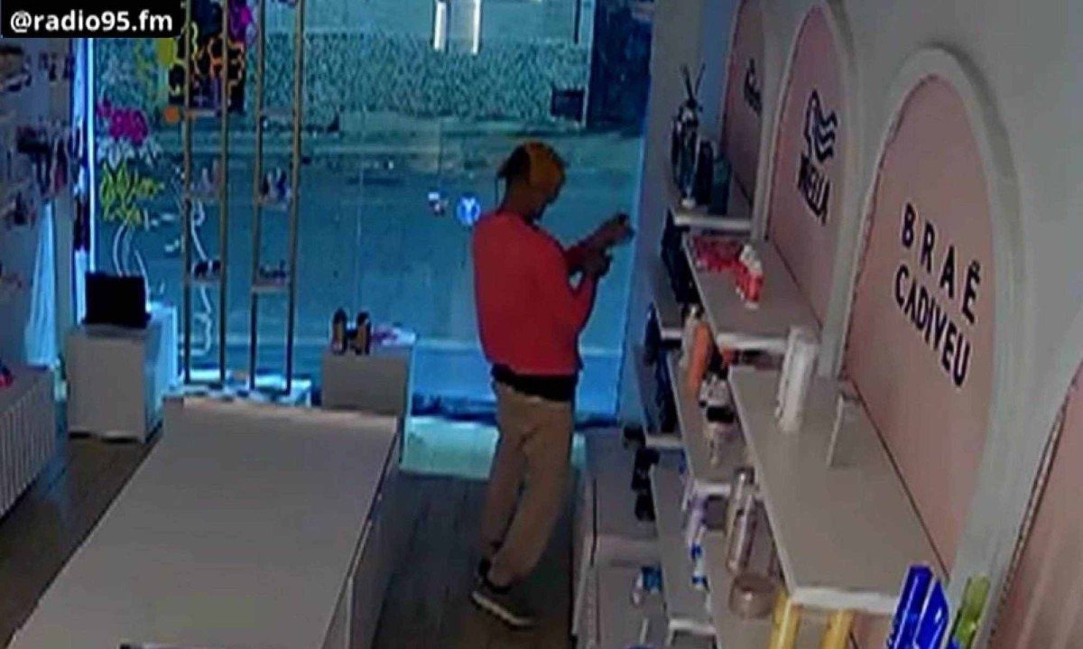 Homem borrifa perfume e sente o cheiro antes de furtar loja em Nepomuceno, no Campo das Vertentes -  (crédito: Reprodução/Rádio 95fm)