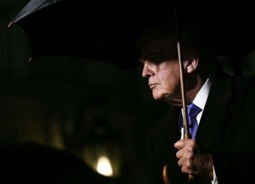 Trump segura guarda-chuva ao sair da Casa Branca, em Washington (EUA) -  (crédito: Foto por BRENDAN SMIALOWSKI / AFP)