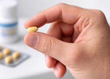 Mão de homem segura pílula de tadalafila: venda do medicamento subiu mais de 2000% nos últimos anos -  (crédito: imagem gerada por inteligência artificial/Acervo Estado de Minas)