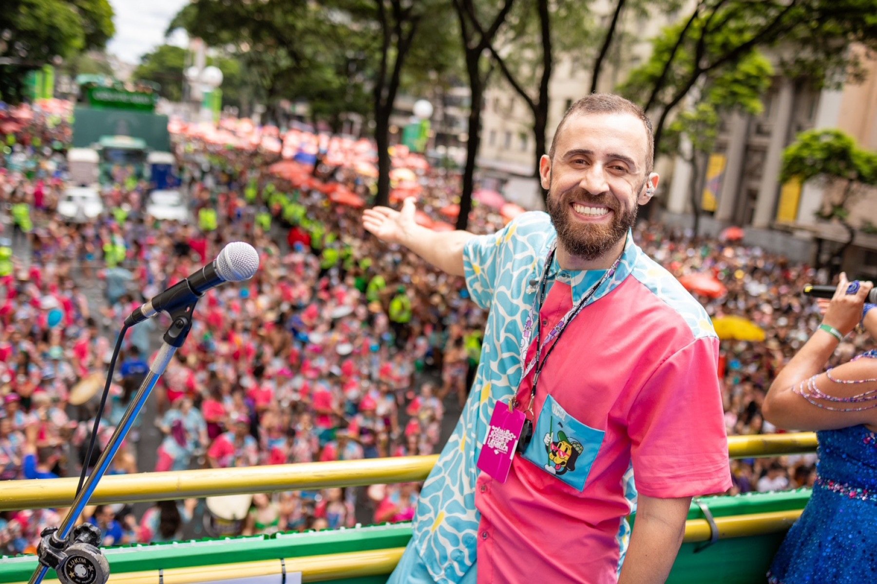  Carnavalesco Melado est&aacute; em cima do trio el&eacute;trico do bloco Quando Come se Lambuza, sorrindo e apontando para a multid&atilde;o que dan&ccedil;a l&aacute; embaixo